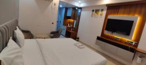 a hotel room with a bed and a flat screen tv at RrHEAVENSTAY in Nalmatha