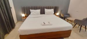 a bedroom with a large white bed with two chairs at RrHEAVENSTAY in Nalmatha