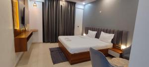 a hotel room with a bed and a television at RrHEAVENSTAY in Nalmatha
