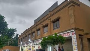a building with people standing outside of it at Hotel Embassy Inn in Ānakhol