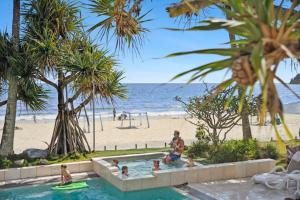 Eine Gruppe von Menschen in einem Schwimmbad neben einem Strand in der Unterkunft Fairshore in Noosa Heads + 56 Fotos