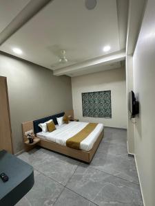 a bedroom with a bed and a tv in it at Hotel Embassy Inn in Ānakhol