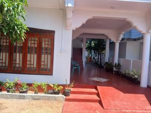 a front porch of a house with plants and flowers at Blue Moon Rest Inn in Trincomalee +30 photos