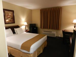 a hotel room with a large bed and a window at Luxury Inn & Suites Troy in Troy