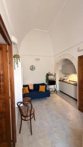 a living room with a blue couch and a kitchen at Lumia - Casa Vacanze in Martina Franca