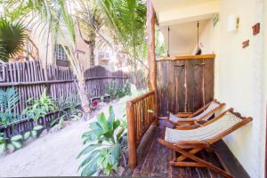 een paar stoelen op de veranda van een huis bij Playa Canek Beachfront Eco Hotel in Tulum