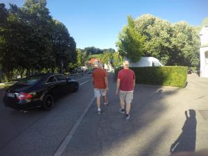 two men walking down a street with a car at RUBY LODGINg in Banilad