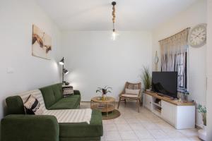 a living room with a couch and a tv at Iriada House in Rhodes Town