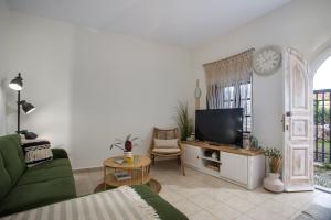 a living room with a television and a green couch at Iriada House in Rhodes Town