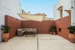 a patio with a table against a brick wall at Iriada House in Rhodes Town
