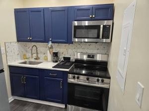 a kitchen with blue cabinets and a stove and a microwave at G O G Building in Darby