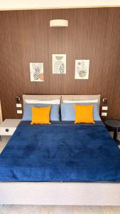 a bed with blue sheets and orange pillows at Lumia - Casa Vacanze in Martina Franca