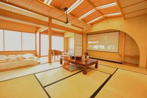 a room with a tv and a bed and a table at 熱海の隠れ里 in Atami