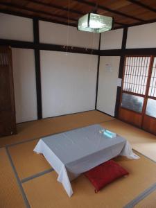 a room with a table in the middle of it at The Asagiri Guest House in Tanabe