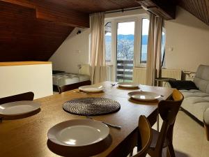 a wooden table with plates on it in a living room at Apartments Lajk in Lesce
