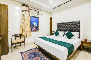 a bedroom with a bed and a chair and a window at Hotel Saffron Inn in New Delhi