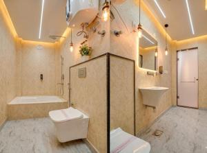 a bathroom with a toilet and a sink and a tub at Hotel Sky Nest Suites Near IGI Airport Delhi in New Delhi