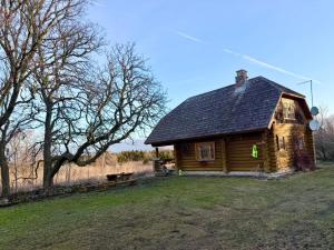 a small wooden house with a green sign on it at Pitsinina Log House in Kaugatuma