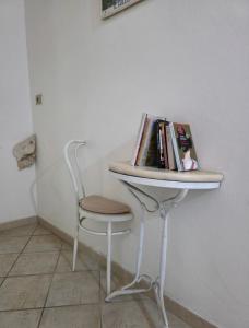 a table with a chair and books on it at Il Melangolo in SantʼAntìoco