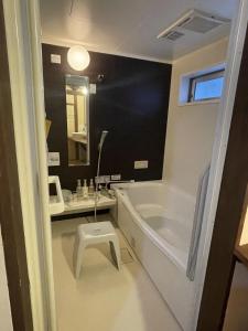 a bathroom with a tub and a sink and a stool at こちの宿 in Yamaga +21 photos