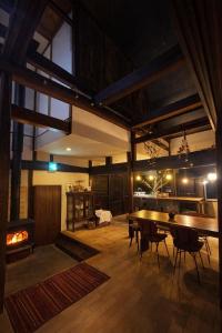 a large room with a table and chairs and a fireplace at こちの宿 in Yamaga