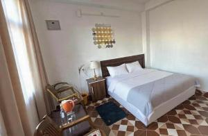 a bedroom with a bed and a checkered floor at Sunrise View Farm-stay -Narkanda in Shimla