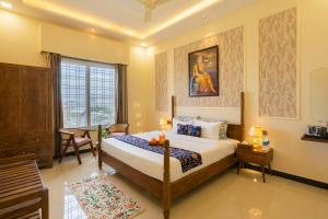 a bedroom with a bed and a table and a window at Kamdhenu - Luxurious stay in Udaipur +77 photos
