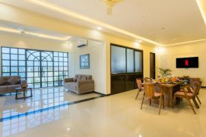 a dining room and living room with a table and chairs at Kamdhenu - Luxurious stay in Udaipur