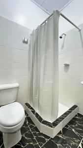 a bathroom with a toilet and a shower curtain at Hostal Maravilla Amazónica in Iquitos +30 photos