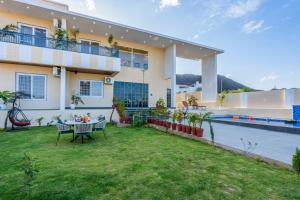 a villa with a garden and a swimming pool at Kamdhenu - Luxurious stay in Udaipur