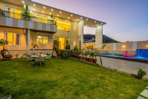 a house with a lawn in front of it at Kamdhenu - Luxurious stay in Udaipur