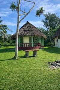 a small hut with a thatched roof in a field at Leimalo's Bungalow in Port Vila