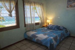 a bedroom with a bed with a view of the beach at Leimalo's Bungalow in Port Vila