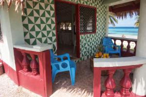 a house with chairs and a balcony with the beach at Leimalo's Bungalow in Port Vila