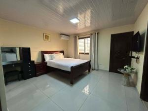 a bedroom with a bed and a television in it at Moima Plaza Guesthouse in Monrovia