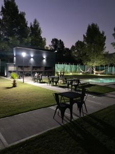 a group of tables and benches in a park at night at El Atardecer Complejo Turístico in San Rafael