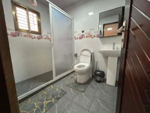 a bathroom with a toilet and a sink at Moima Plaza Guesthouse in Monrovia +5 photos