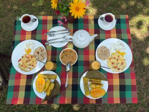 a picnic table with plates of food and cups of coffee at Brenley B Bungalow in Talalla South