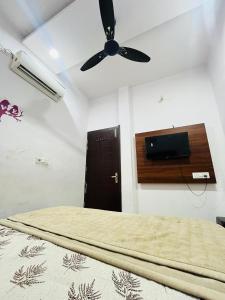 a bedroom with a bed with a ceiling fan at Bloom Hotel in Jagādhri