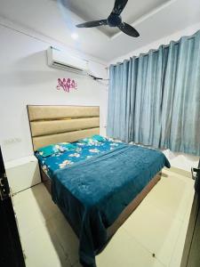 a bedroom with a bed and a ceiling fan at Bloom Hotel in Jagādhri