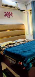 a bed in a room with a wooden headboard at Bloom Hotel in Jagādhri