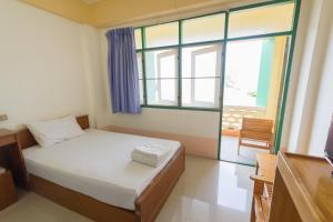 a small bedroom with a bed and a window at Mont Talay Hotel in Prachuap Khiri Khan