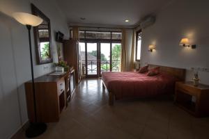a bedroom with a bed and a dresser and a window at Ecosfera Hotel & Spa in Canggu