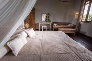 a bedroom with a large bed with white pillows at Ecosfera Hotel & Spa in Canggu