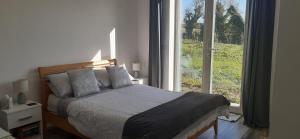 a bedroom with a bed and a large window at Cozy Double Ensuite Room in Ennistymon