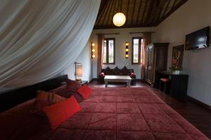 a living room with a couch with red pillows at Ecosfera Hotel & Spa in Canggu