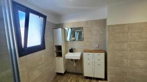 une petite salle de bain avec un lavabo et une fenêtre dans l'établissement RUSTIC SELF-INN, à Rhodes 28 autres photos