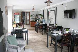 a dining room with tables and chairs in a restaurant at The Nightingale Guesthouse in Bloemfontein