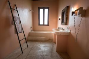 a bathroom with a tub and a sink and a ladder at Ecosfera Hotel & Spa in Canggu