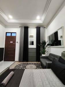 ein Wohnzimmer mit einer Couch und einer Tür in der Unterkunft Mini Concept Hotel in Kuala Terengganu
